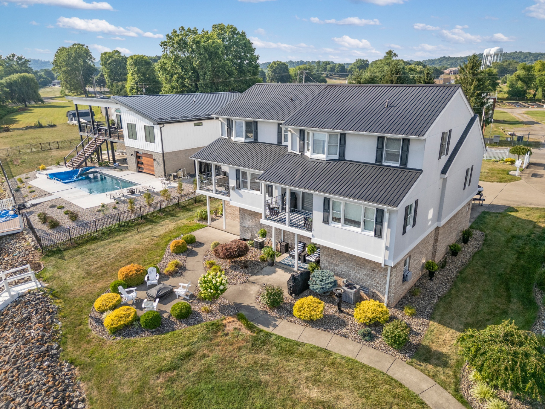 Aerial view of two-story home with pool and landscaped gardens