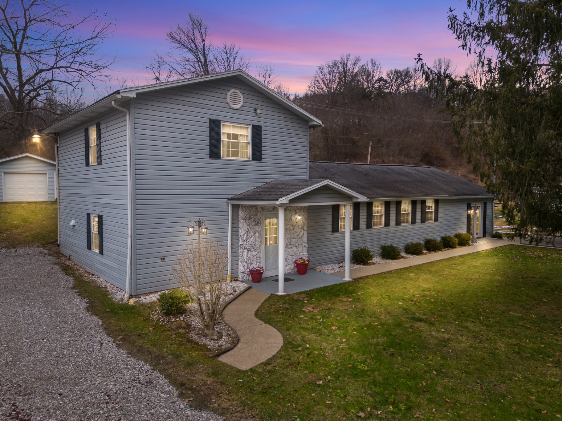 Two-story gray home at dusk with pink and purple twilight sky